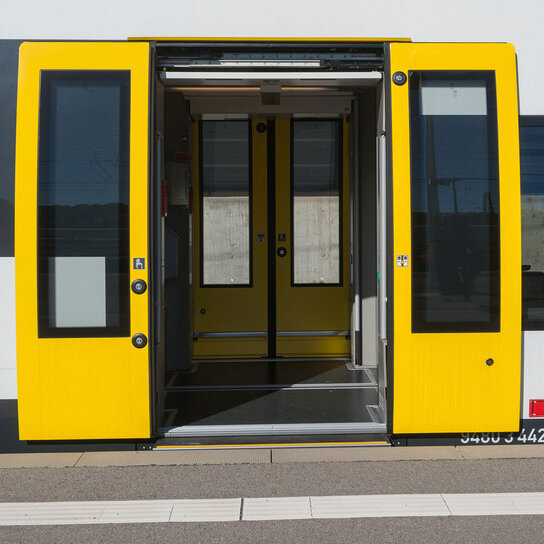 bwegt Zug mit offenen Türen an Bahnsteig 