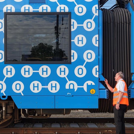 Bahnmitarbeiter vor einem Brennstoffzellenzug