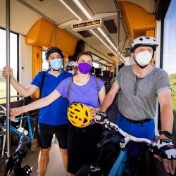 BahnfahrerInnen stehen mit Fahrrädern in Fahrradabteil der Bahn