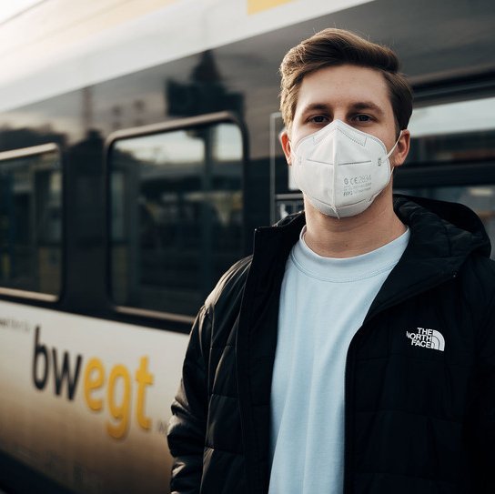 Jugendlicher mit FFP2 Maske vor bwegt Zug