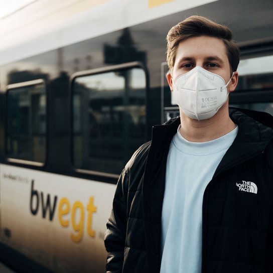 Jugendlicher mit FFP2 Maske vor bwegt Zug